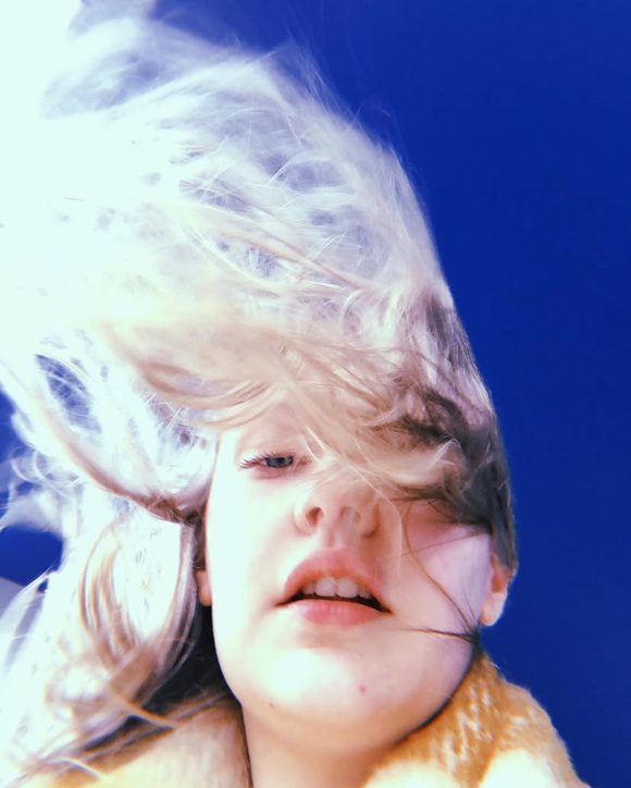 Portrait of Jodie Cranen with windswept hair against a blue sky