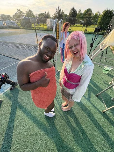 Two actors laughing on set